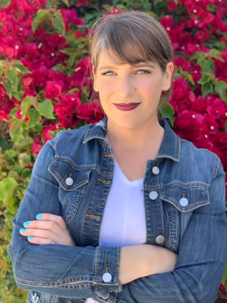 Jennifer DiCenzo standing in front pink bougainvillea wearing a denim shirt