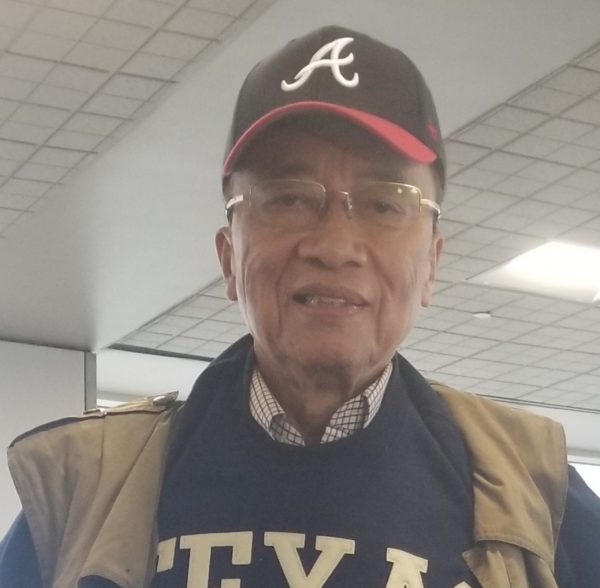 Dr. David Yuen wearing a baseball cap and glasses