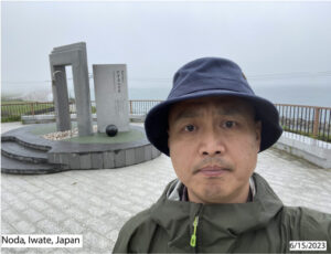 Shou Ma wearing a blue bucket hat and green jacket at Noda, Iwate, Japan