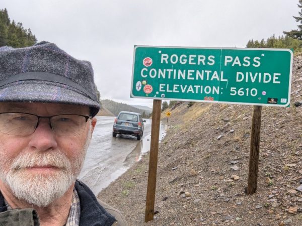 Rogers Hardy standing on Rogers Pass at the continental divide